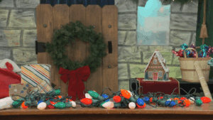 GIF of Kent Cook sketch showing Kent struggling with Christmas lights on the foam board North Pole set with carved stone texture and window.