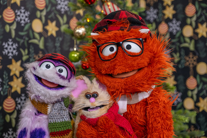 Sam and Murphy monster puppets with Buttons the Christmas Mouse beside the decorated tree.