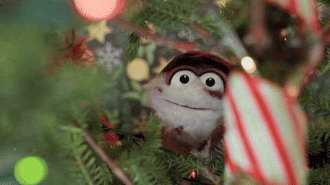 Sam and Murphy peer through the tree branches at Buttons the Christmas Mouse in a practical in-camera reveal.